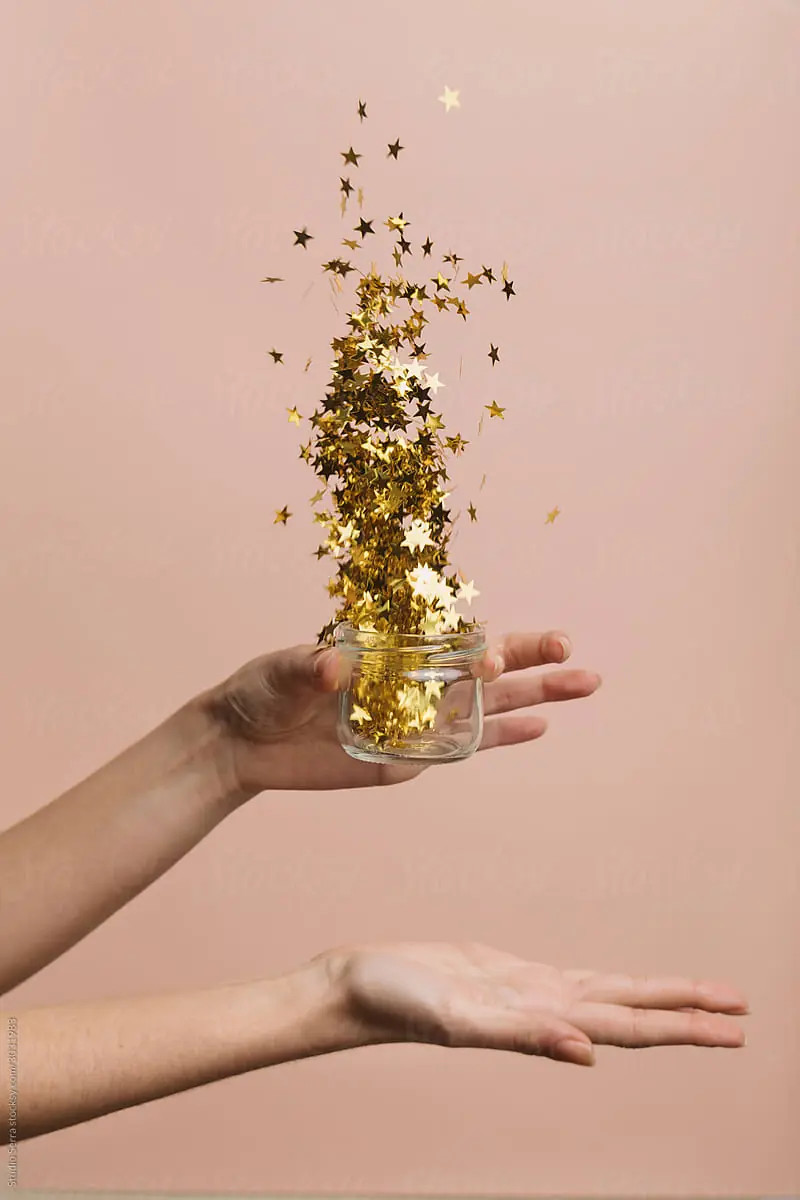 Hand holding jar of gold stars